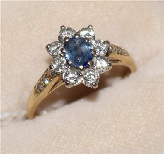 An 18ct gold, sapphire and diamond cluster ring with diamond-set shoulders, size L.